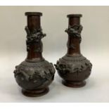 A pair of Japanese bronze bottle neck vases, the ovoid bodies bearing applied relief carved birds in