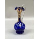 A Venetian blue glass ewer, the bulbous body decorated with white flowers and gilding, with