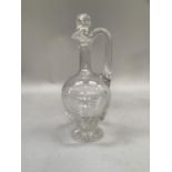 A glass ewer with stopper and cut decoration to bulbous body on foot, 25cm high