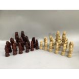 A composite carved chess set in cream and burgundy