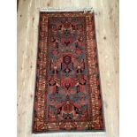 A wool rug of salmon, pink, blue and ivory of Middle Eastern style, 153cm by 80cm together with a