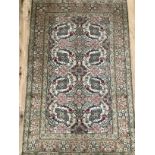 A Persian rug in pale green, rose, ivory and blue, the ivory field filled with medallions in a