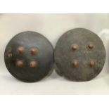 Pair of African hide shields, of circular form with four metal studs, with velvet hand straps to