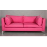 A pink fabric sofa with loose back, seat and arm cushions on aluminium square legs, 218cm wide x