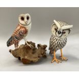 Two carved wooden models of a snowy owl and a barn owl, the barn owl mounted on a piece of