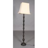 A Middle Eastern style cast metal standard lamp, the baluster stem moulded in relief with foliate