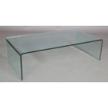 An all glass coffee table on panel ends, 132cm wide x 69cm deep x 36cm high approximately