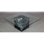 A glass and marble base coffee table, the bevelled glass surface resting on a canted marble cube