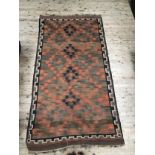A woven kilim rug with lozenge medallions of orange, green and black on red field with geometric