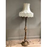 A gilt and polychrome moulded standard lamp with turned and reeded central column with moulded