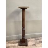 A mahogany torchere with turned and square support on pediment base, 100cm high
