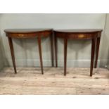 Pair of reproduction mahogany demi lune tables with inlaid cartouches to the front on straight legs,