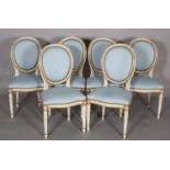 A set of six French style dining chairs, oval upholstered back and serpentine seat, on stop fluted