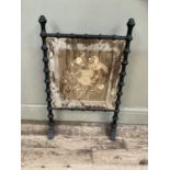 A mid Victorian ebonised firescreen having a bobbin turned frame and silk embroidered panel