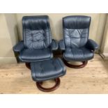 A pair of blue Stressless chairs and a foot stool, on central round supports