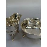 A George V silver sugar bowl and cream jug, London 1925, each on three lion paw feet