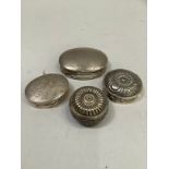 Three continental silver pill boxes of various sizes with moulded decoration together with a base