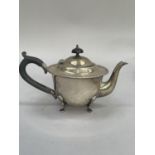 A George V silver teapot Birmingham 1923 of circular outline with ebonised handle and finial, barley