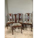 A set of four walnut dining chairs of Queen Anne style on cabriole legs