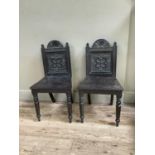 Pair of oak hall chairs with carved sun crest above geometric carving on turned legs A/F, 43cm wide