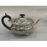 An Edward VII silver tea pot, London 1909 oval outline with ebonised handle and lobbed finial on