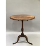 An oak oval tilt top table, on turned support and on tripod base,73cm high, 57cm wide