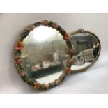 Circular wall mirror the frame moulded with polychrome vines, roses and foliage on a gilt ground,