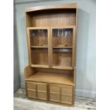 A Nathan teak display cabinet having a top compartment above glazed shelving over two doors, 191cm