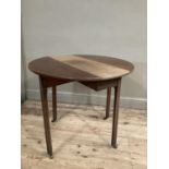 A mahogany drop leaf dining table on square legs and with brass casters