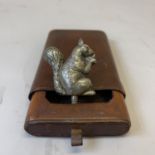 A motorcycle mascot in the shape of a squirrel tightly holding its nuts, approximately 5cm tall,