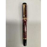 A Parker fountain pen, 18ct. gold nib, rouge marbled and black case with gilt clip and bands.