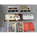 A collection of 1930's and later UK and world postal stamps in a red pictorial bound album, a