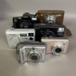 A Minolta Dynax 303si SLR camera, a Yashica Zoomtec film camera and a Bencini Koroll, three