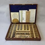 An early 20th century cased set of opticians testing lenses in fitted mahogany box, with a number of