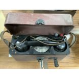 A vintage Post Office Bakelite field telephone in hard plastic case with leather carrying strap