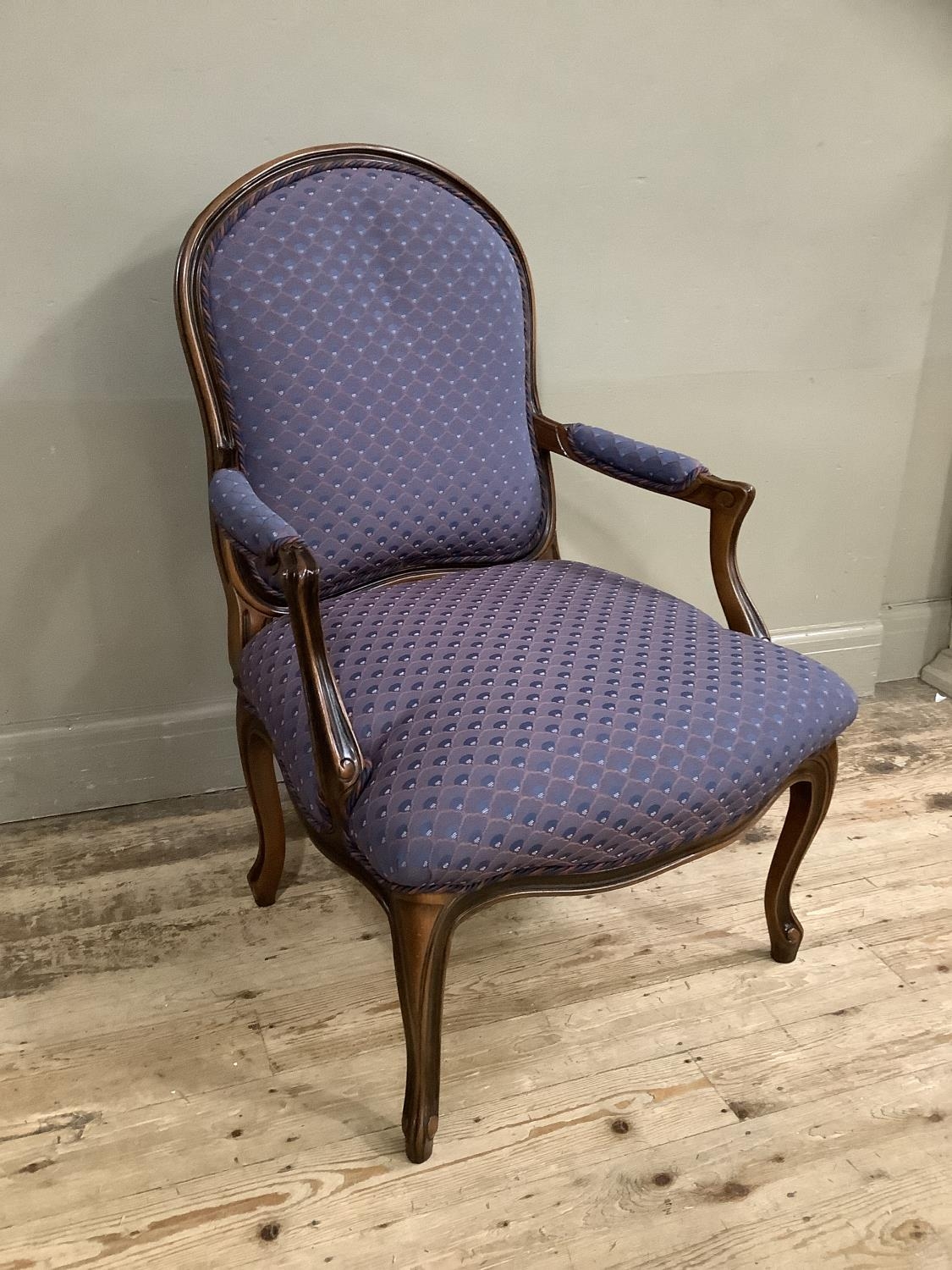 A reproduction French style open armchair on cabriole legs, upholstered in blue and orange scalloped