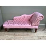 A reproduction chaise long upholstered in pink satin Jaccard fabric, on turned mahogany legs on