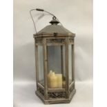 A modern bleached fruitwood and glass storm lantern with carved and pierced panels with metal top