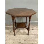 An Edwardian octagonal window table with turned legs, carved apron and under tier, on casters,