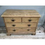 An early 20th century light oak chest of two short above two long drawers with carved front apron