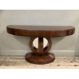 A reproduction console table with support formed of abstract curves and mirrored back, demi-lune