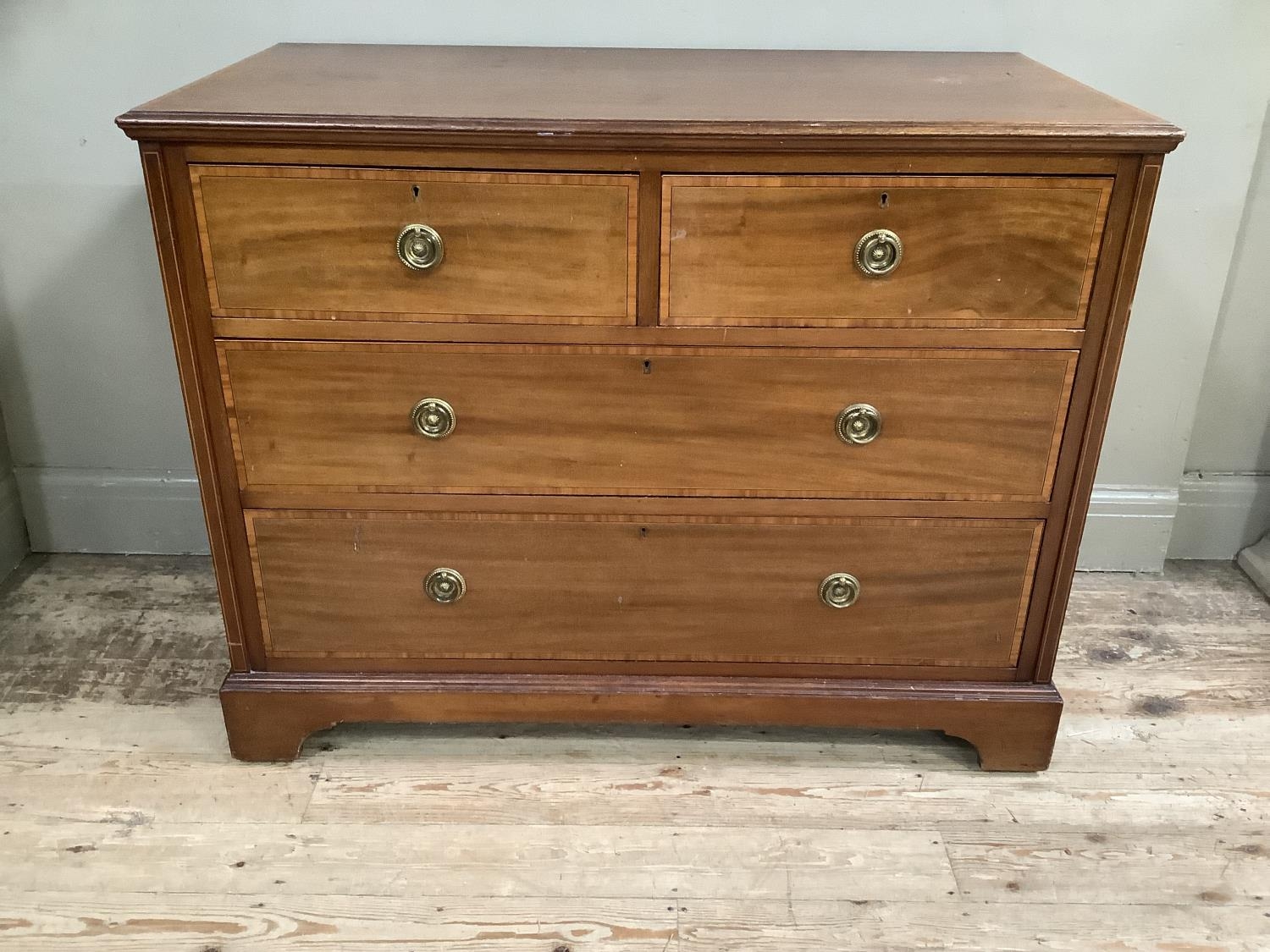 An Edwardian mahogany and satinwood cross banded chest of two short over two long drawers with brass