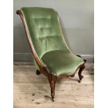 19th century mahogany button back nursing chair with carved frame on cabriole legs on brass castors,