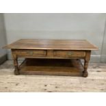 A reproduction oak coffee table, two small drawers, brass handles, on turned supports with under