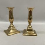 A pair of moulded Georgian brass candlesticks with baluster columns and stepped bases 16cm high