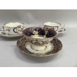 Pair of 19th century cabinet cups and saucers with batwing handles and flowers in blue and gilt