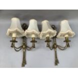 A pair of brass twin wall lights cast with rope decoration, 45cm high, fringed shades