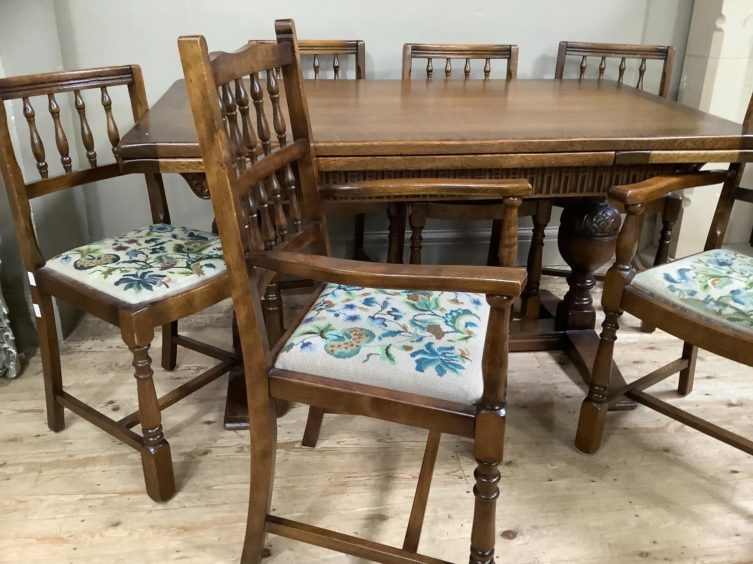 An oak twin baluster support drawer leaf dining table with carved apron together with four spindle