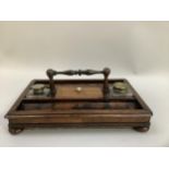Walnut inkstand with two pen slides and turned handle, central lidded compartment with bone handle