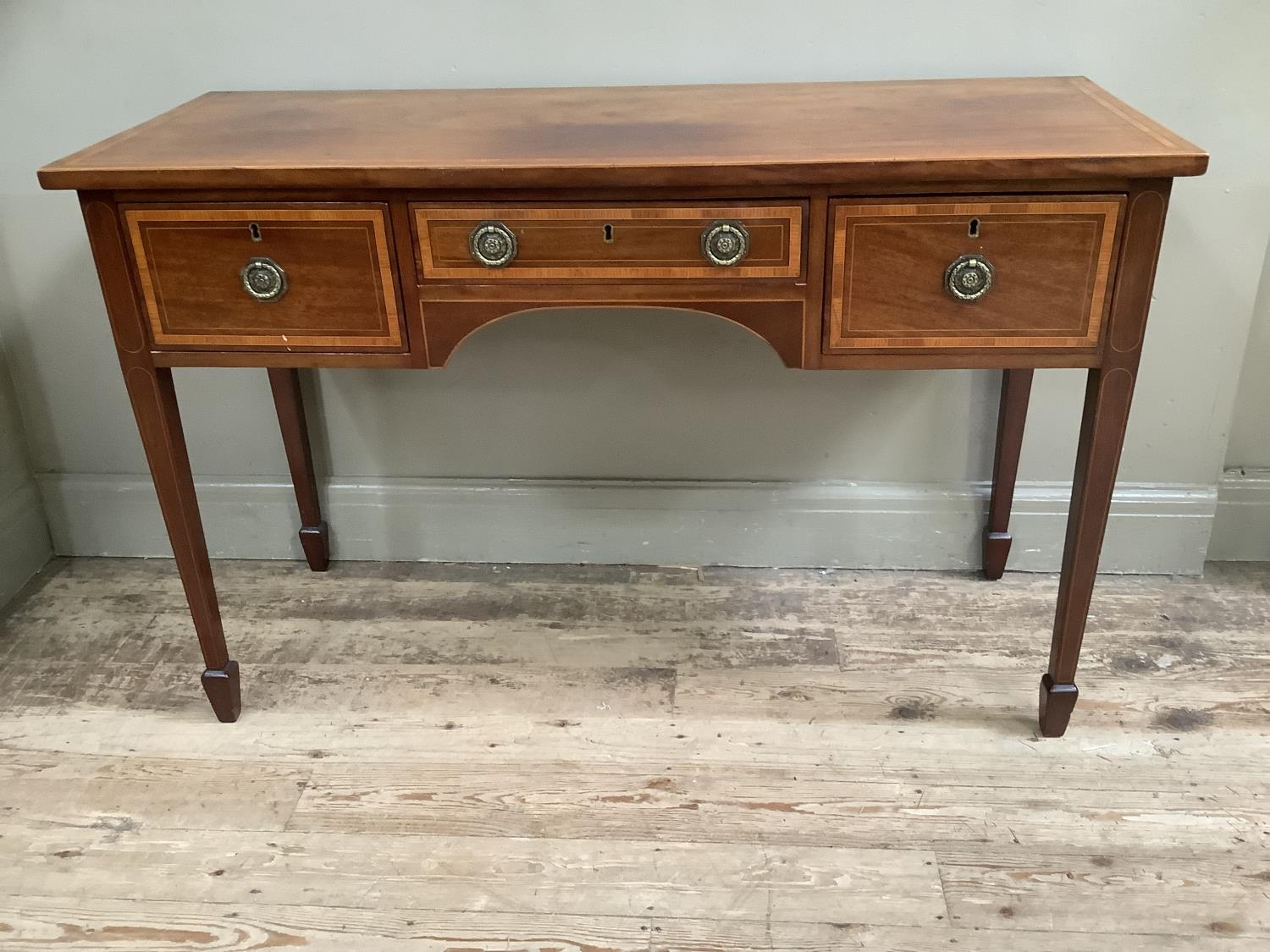 An early 20th century mahogany cross banded sideboard with one long drawer flanked by two short